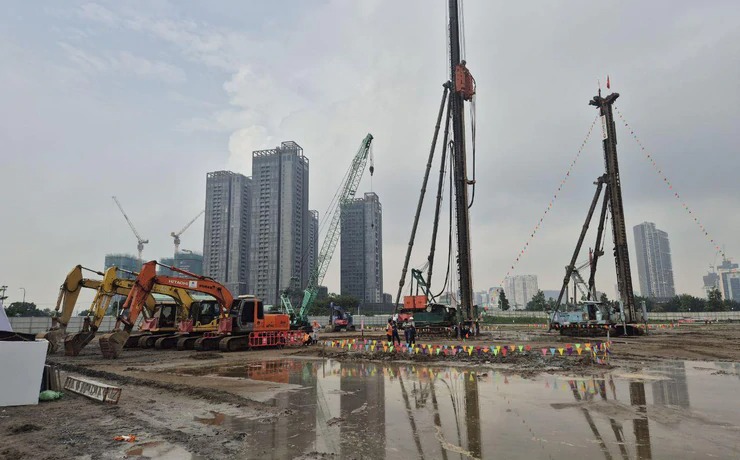 Công trường Lotte Eco Smart City Thủ Thiêm ngày khởi công Máy đóng cọc và máy xúc trên công trường Lotte Eco Smart City Thủ Thiêm, phía sau là các tòa cao tầng khu đô thị mới